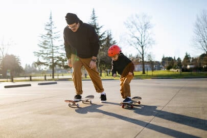 Vader en zoon skateboarden samen in een skatepark