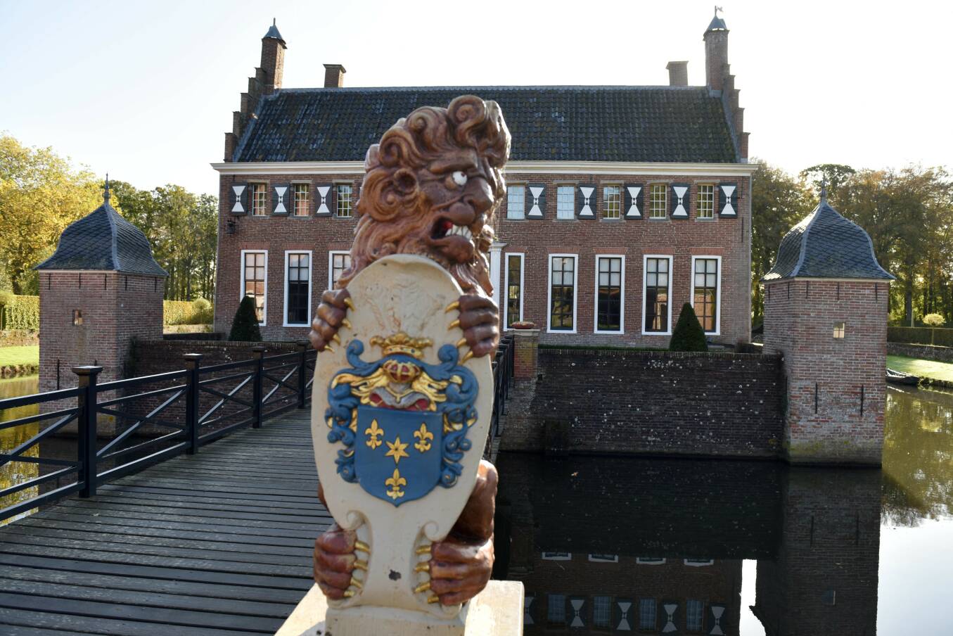 Foto van een historisch gebouw met bij de ingang een beeld van een leeuw
