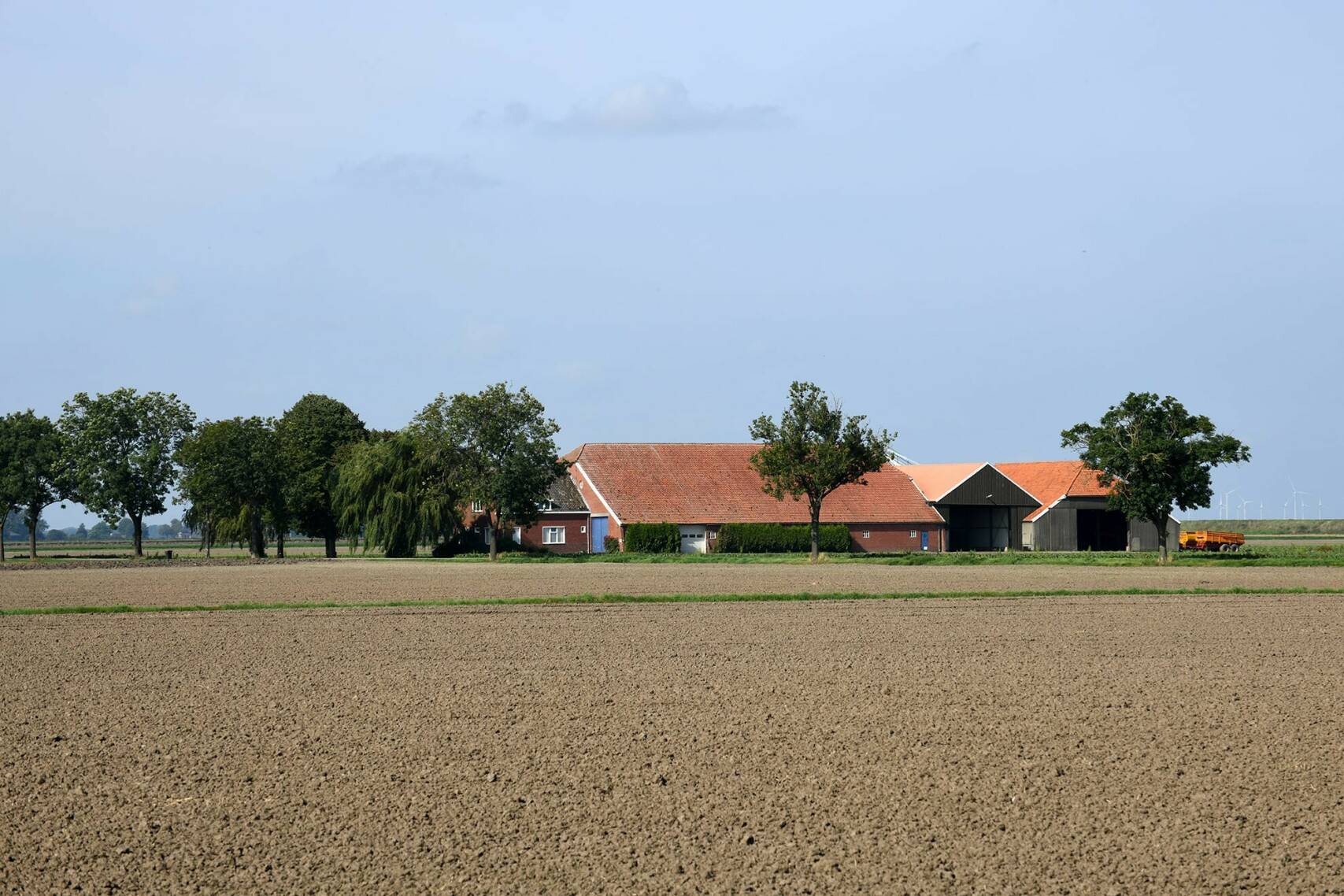 Beeld van een boerderij met daarvoor pas geploegde akkers