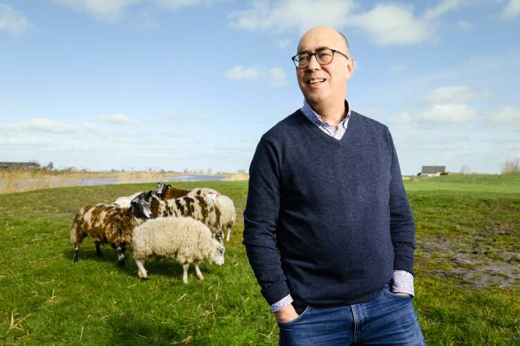 Foto van Ludolph Wentholt in een weiland met schapen