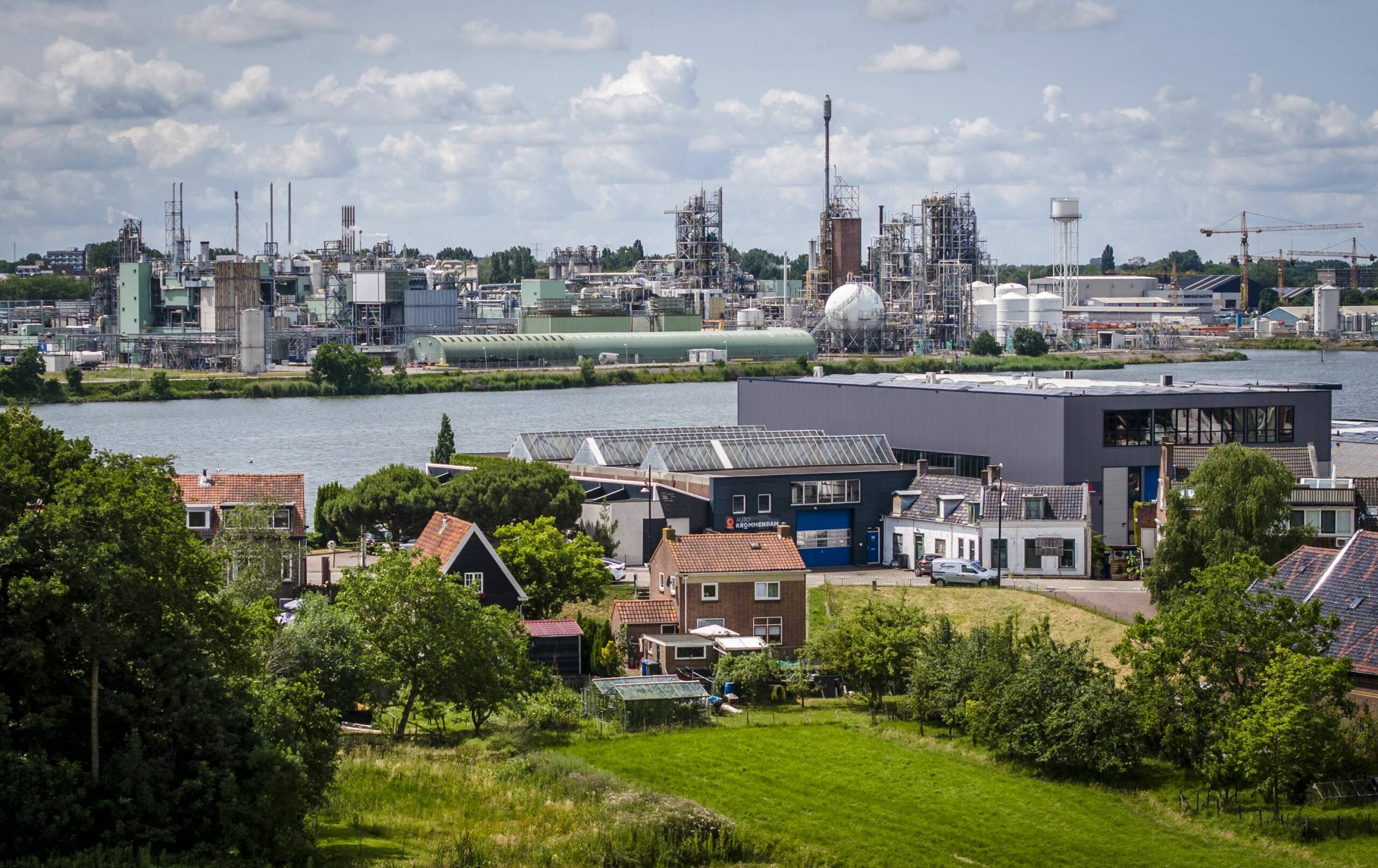 Foto van dorpsgezicht met op de achtergond de chemiefabrieken van Dupont en Chemours