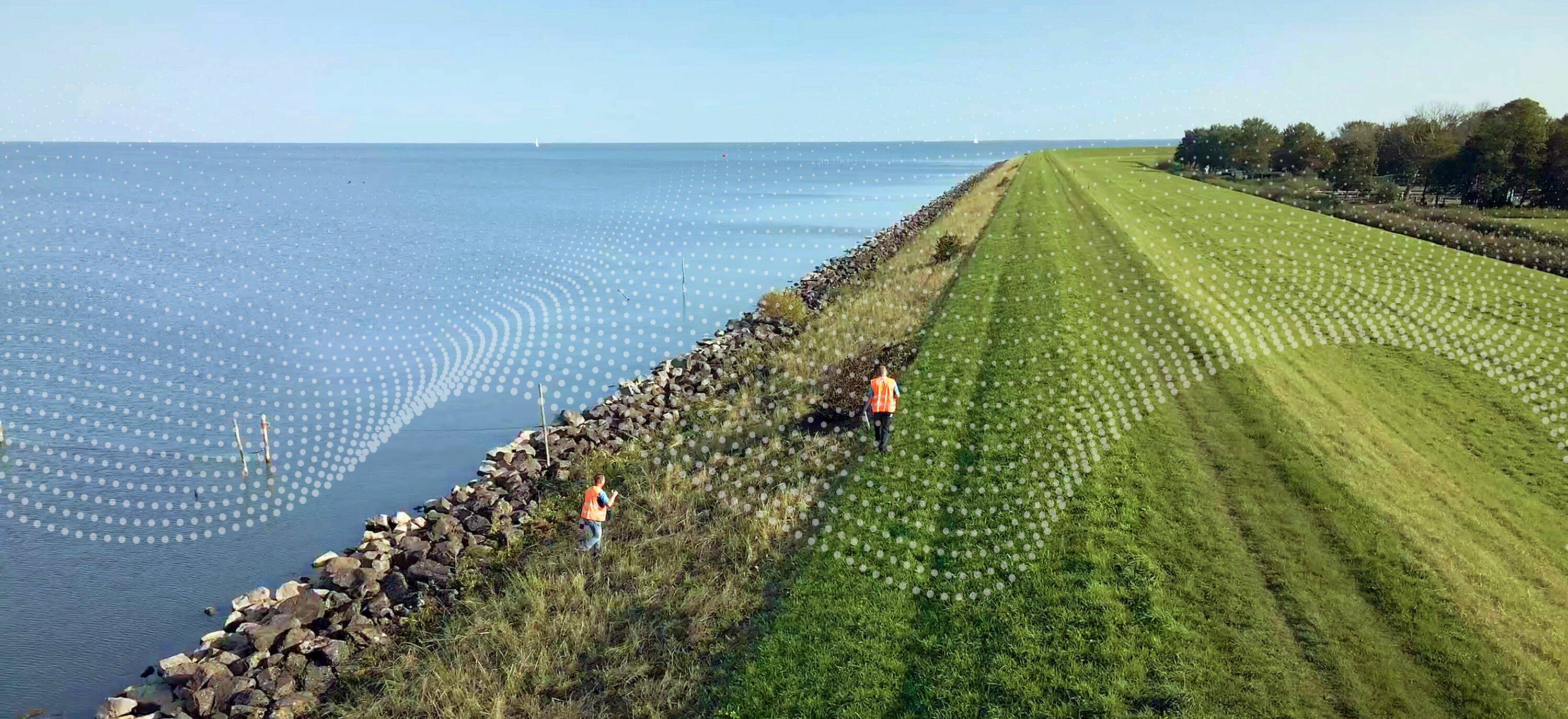 Dronefoto van een handmatige dijkinspectie.