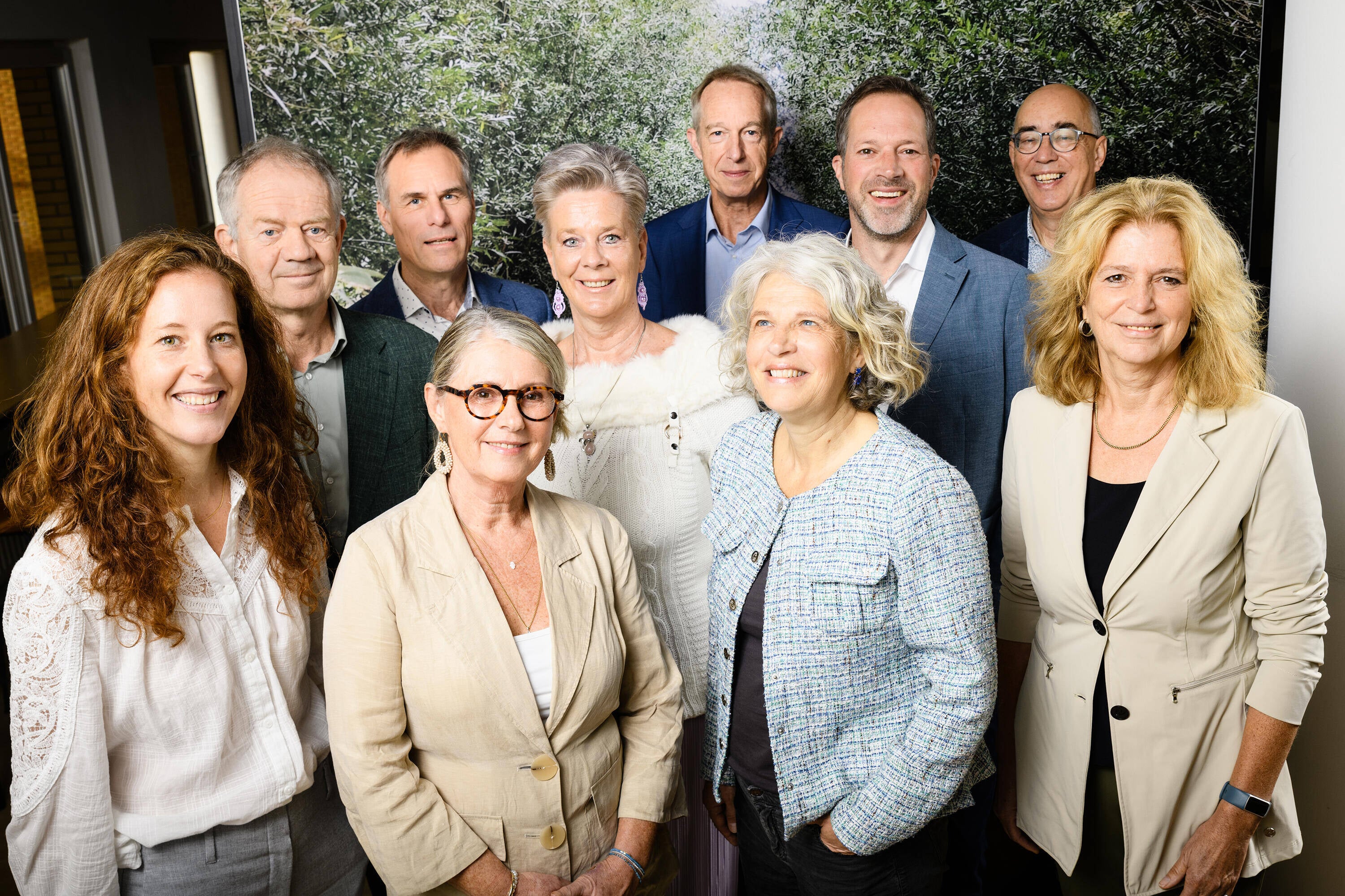 Foto van een Nederlands landschap met op de voorgrond een rivier en een lange rij zonnepanelen en in de verte windmolens