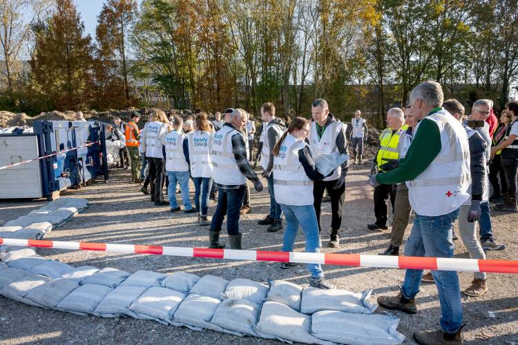 Foto van Ready2Help-vrijwilligers die oefenen met het leggen van zandzakken