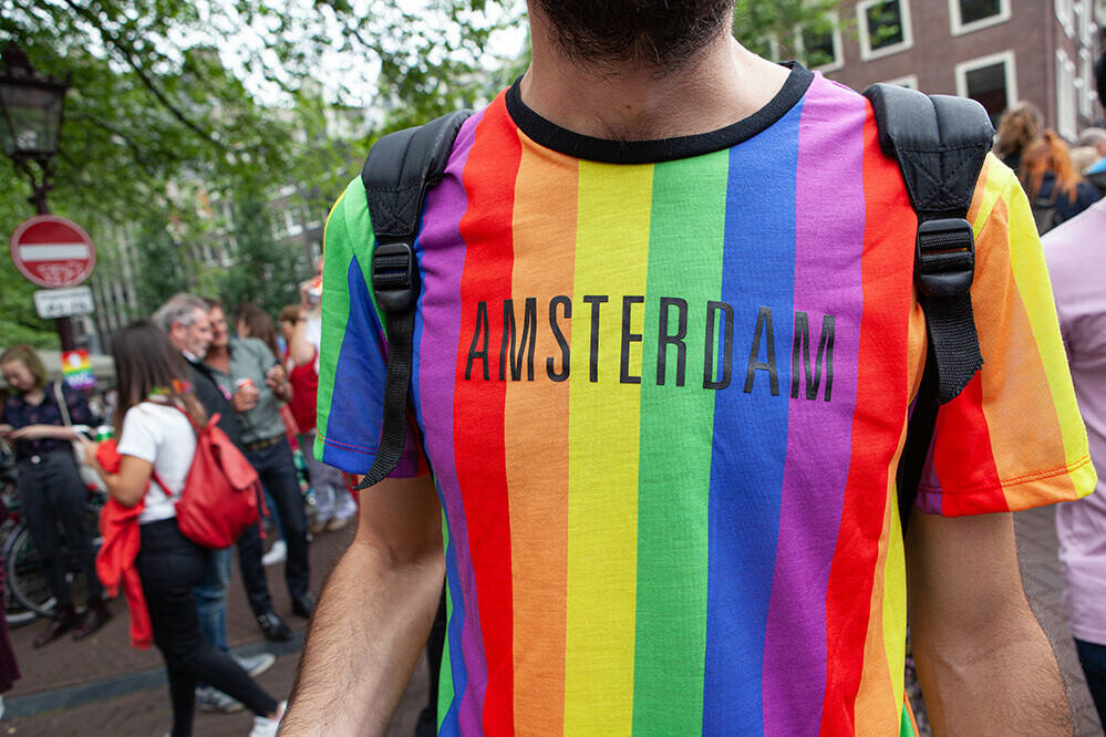 Man met LHBTIQ+ shirt met Amsterdam erop geprint