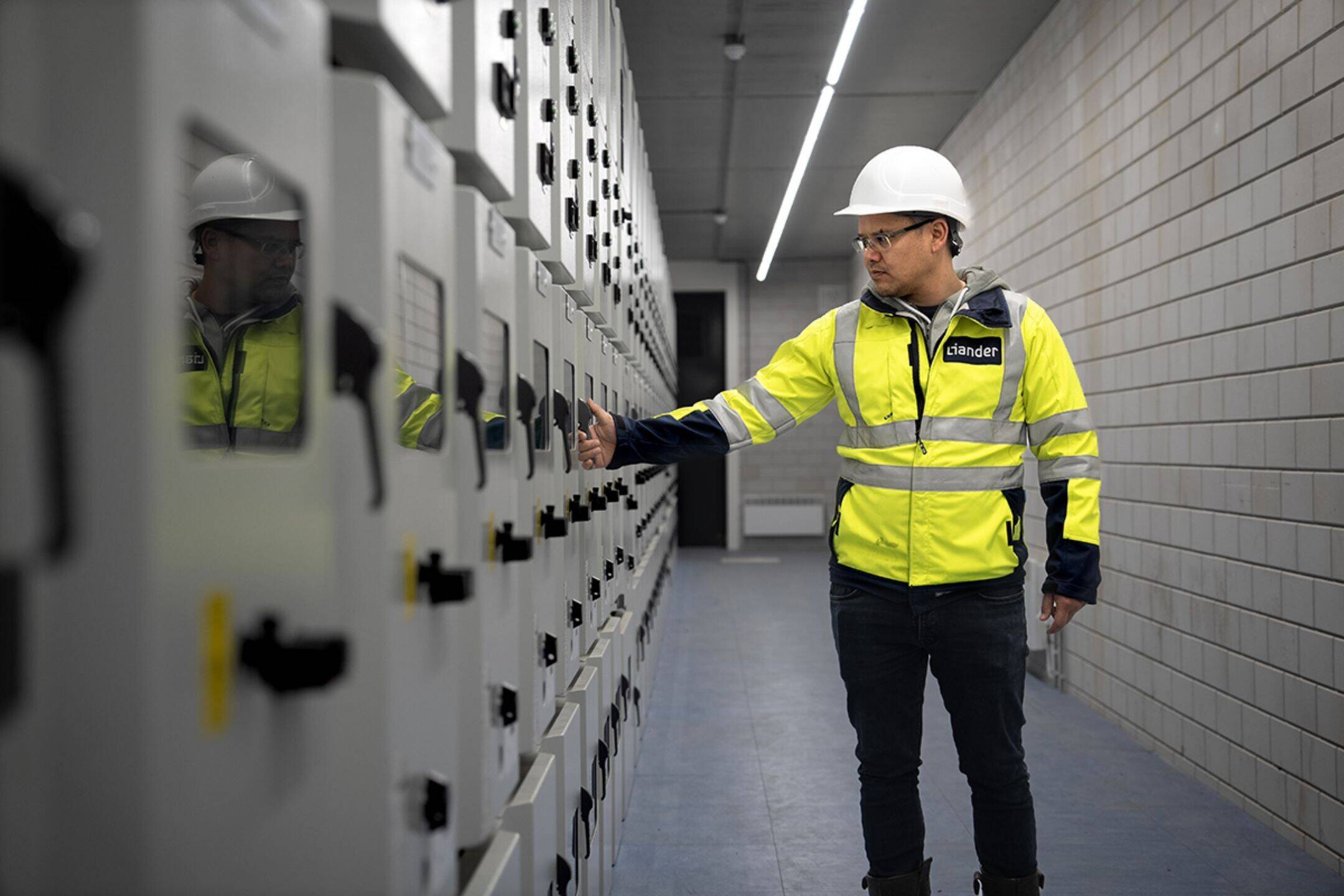 Werknemer Liander bij een schakelkast. Een inkijkje in de binnenkant van een elektriciteitsstation, waar elektrische hoogspanning wordt omgezet naar een lagere spanning.