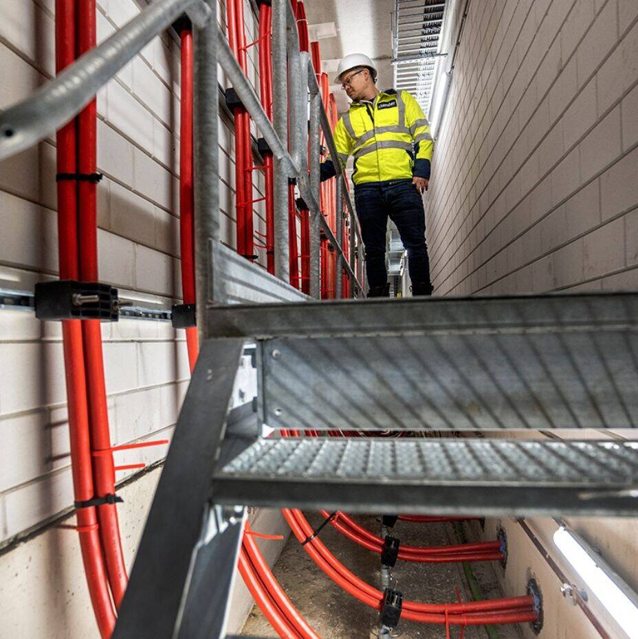 Werknemer Liander bij uitgaande kabels vanuit het elektriciteitsstation naar de omgeving.