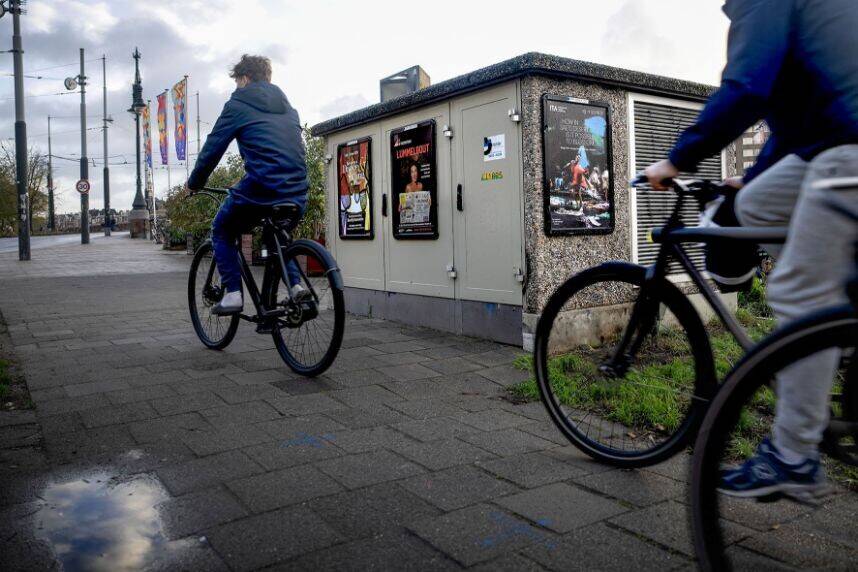 Fietsen rijden langs een transformatorhuisje. 
Transformatorhuisjes zijn onderdeel van de stad en komen in verschillende verschijningsvormen.