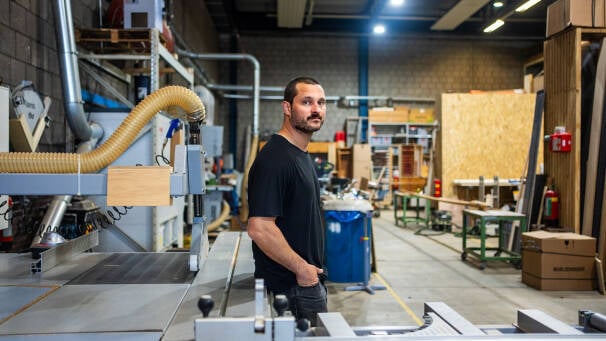 Houtbewerker in zijn werkplaats met machines