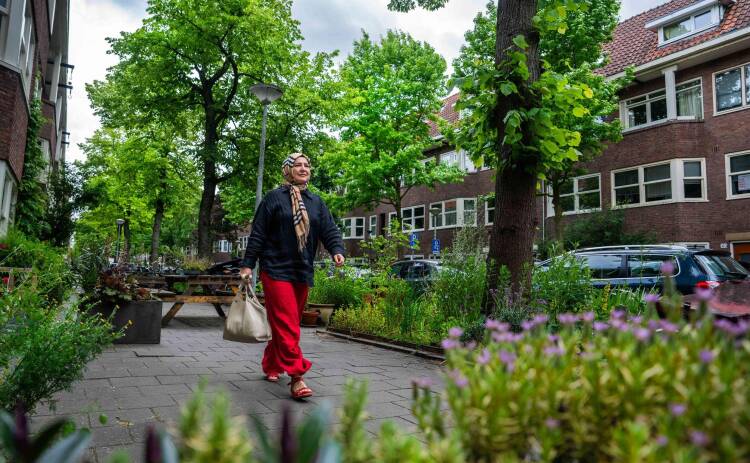 Elektriciteitshuisje in Amsterdam, mensen wandelen voorbij
