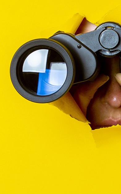 Coverbeeld, vrouw kijkt met verrekijker door een gescheurd gat in een geel vlak