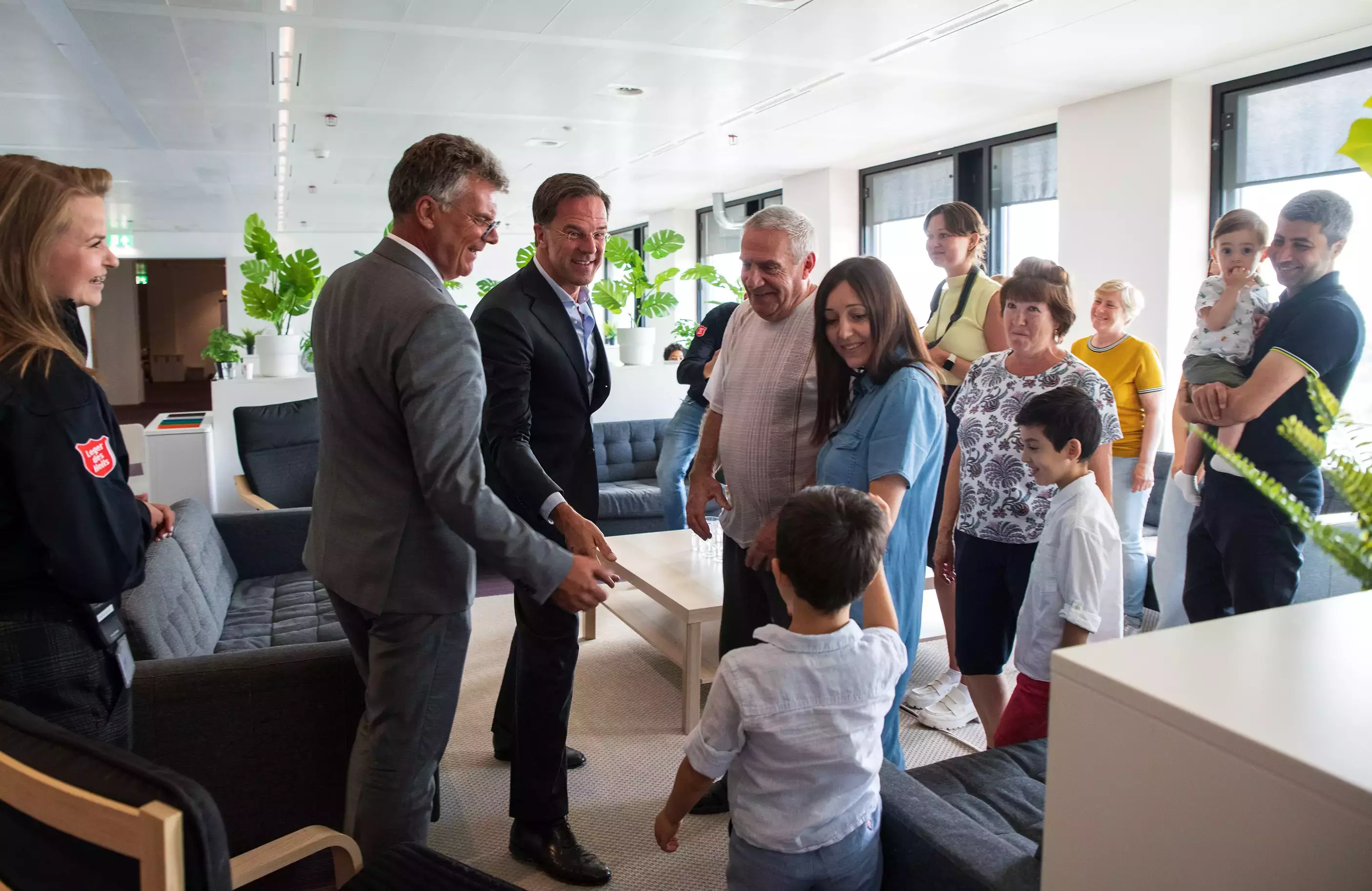 Bezoek van premier Rutte en Commissaris van de Koning aan de opvanglocatie van Oekraïners in Huis van de Provincie. Premier Rutte en ik staan temidden van een familie en geven een jongetje een hand.