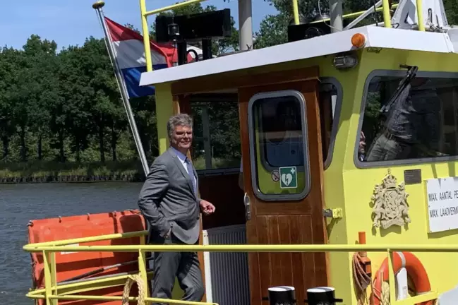 De commissaris aan boord van een schip tijdens zijn boottocht over het Amsterdam-Rijnkanaal