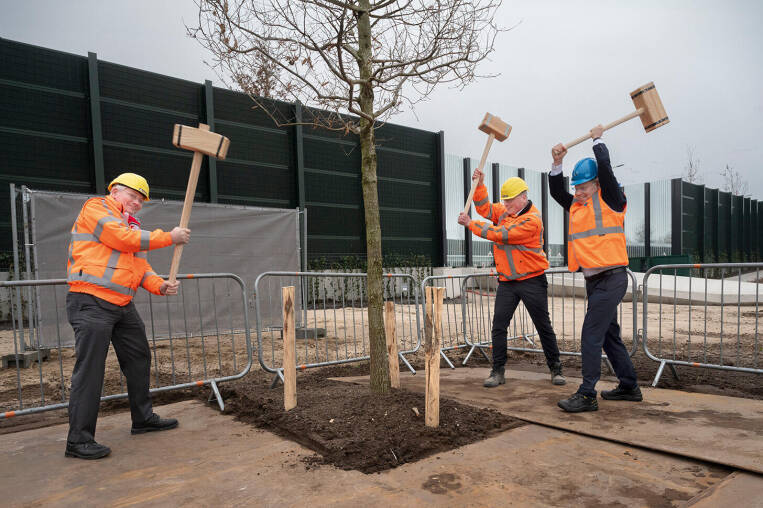 Gedeputeerde André van Schie, wethouder Engbert Stroobosscher van gemeente Veenendaal en directeur Leendert Ripping van Aannemingsmaatschappij Van Gelder slaan boompalen de harde winterse grond in.