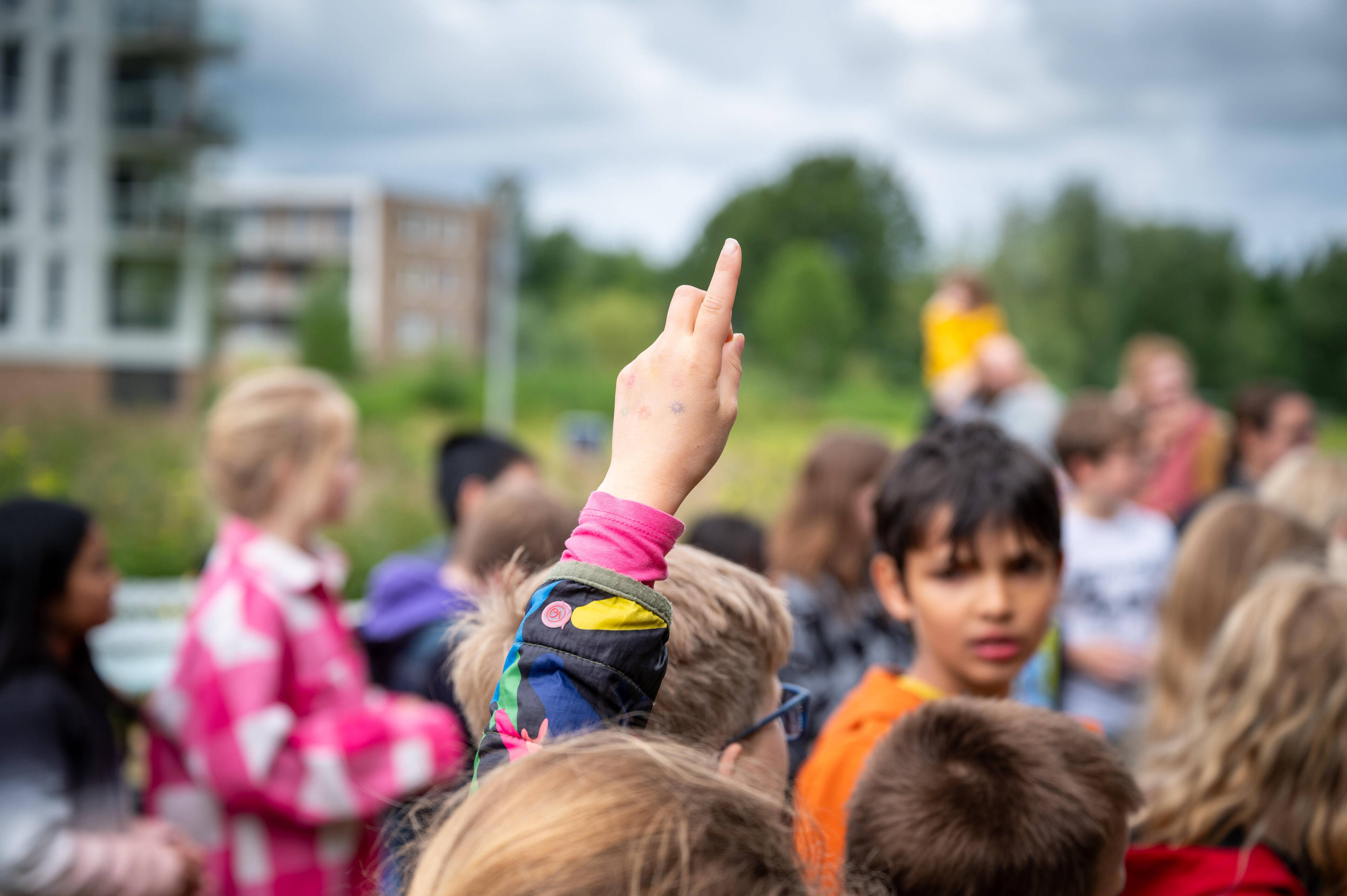 Kinderen bij het Waterwinparklab.
Een groep kinderen deels onherkenbaar op een buitenplek, waarbij een kind zijn vinger in de lucht steekt. Foto van Erik Kampherbeek.