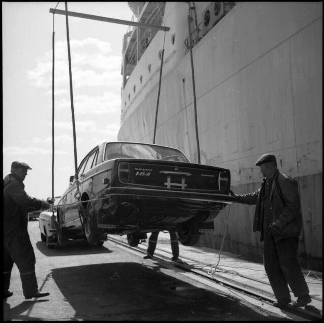 Old Volvo 164 being unloaded from a ship using ropes.