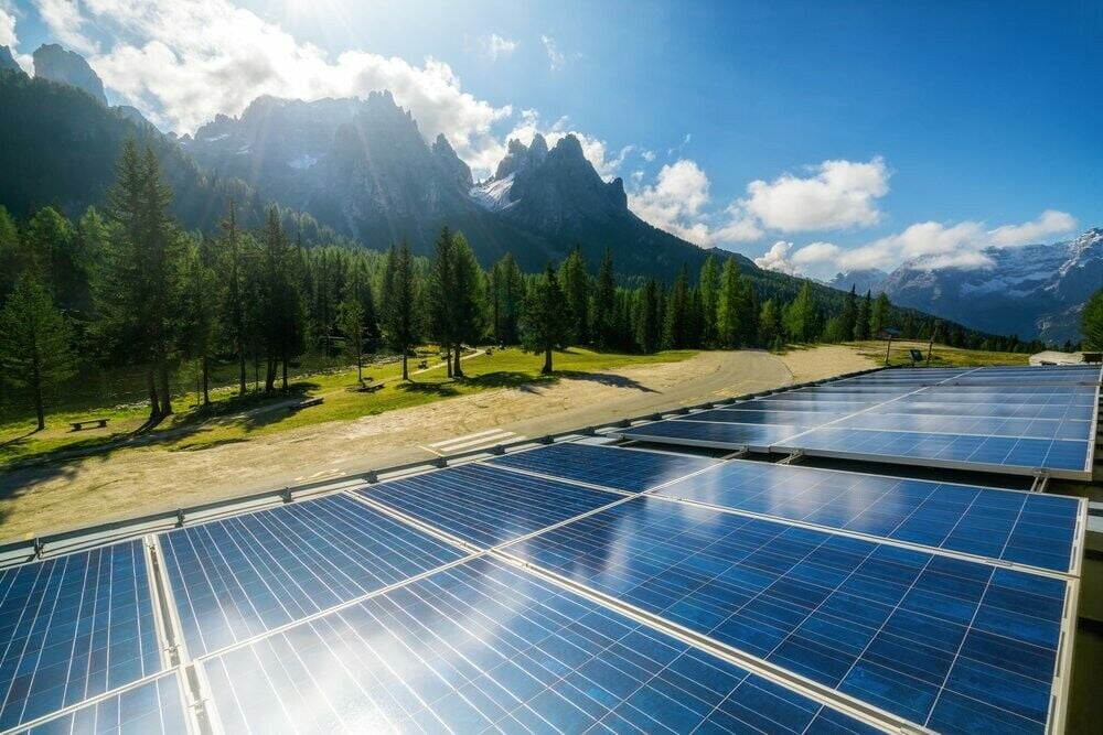 solar panels in sun near mountain and trees