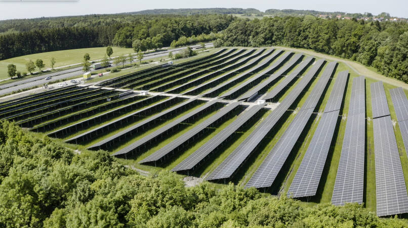 solar panels in sun near mountain and trees