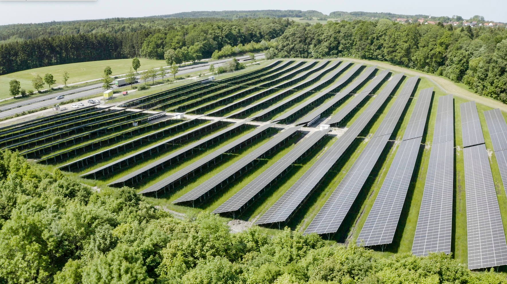 solar panels in sun near mountain and trees