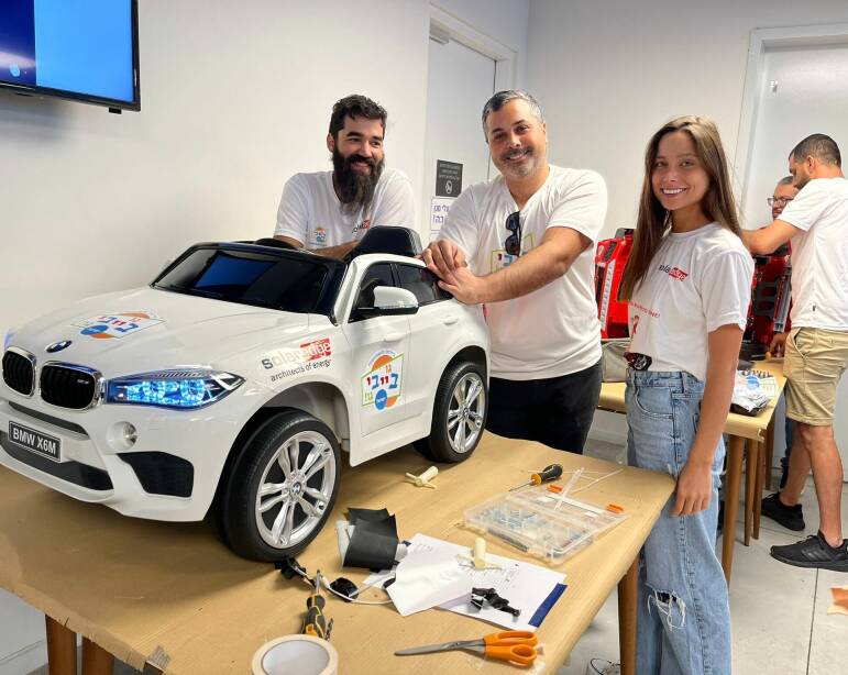 SolarEdge employees volunteering to build child-sized cars for handicapped kids
