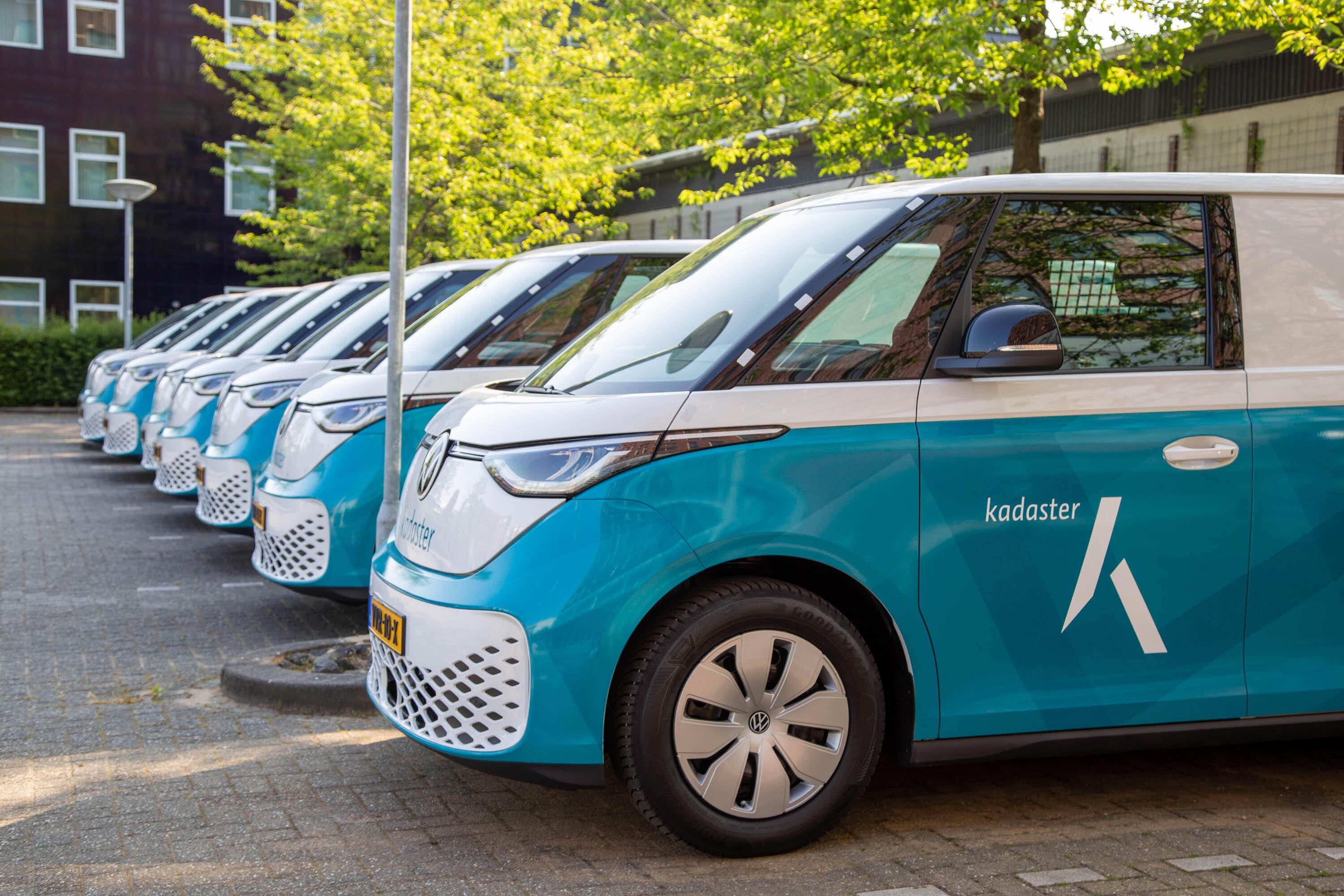 3 landmeters met apparatuur bij een Kadaster auto