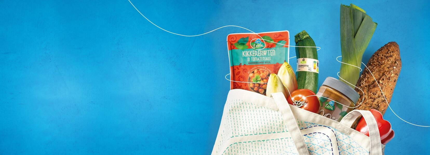 Een close‑up van een hand van een persoon die plantaardige yoghurt van het Albert Heijn‑merk Terra in een klein wit schaaltje schept. De rest van de persoon is niet zichtbaar, focus op hand en schaaltje.