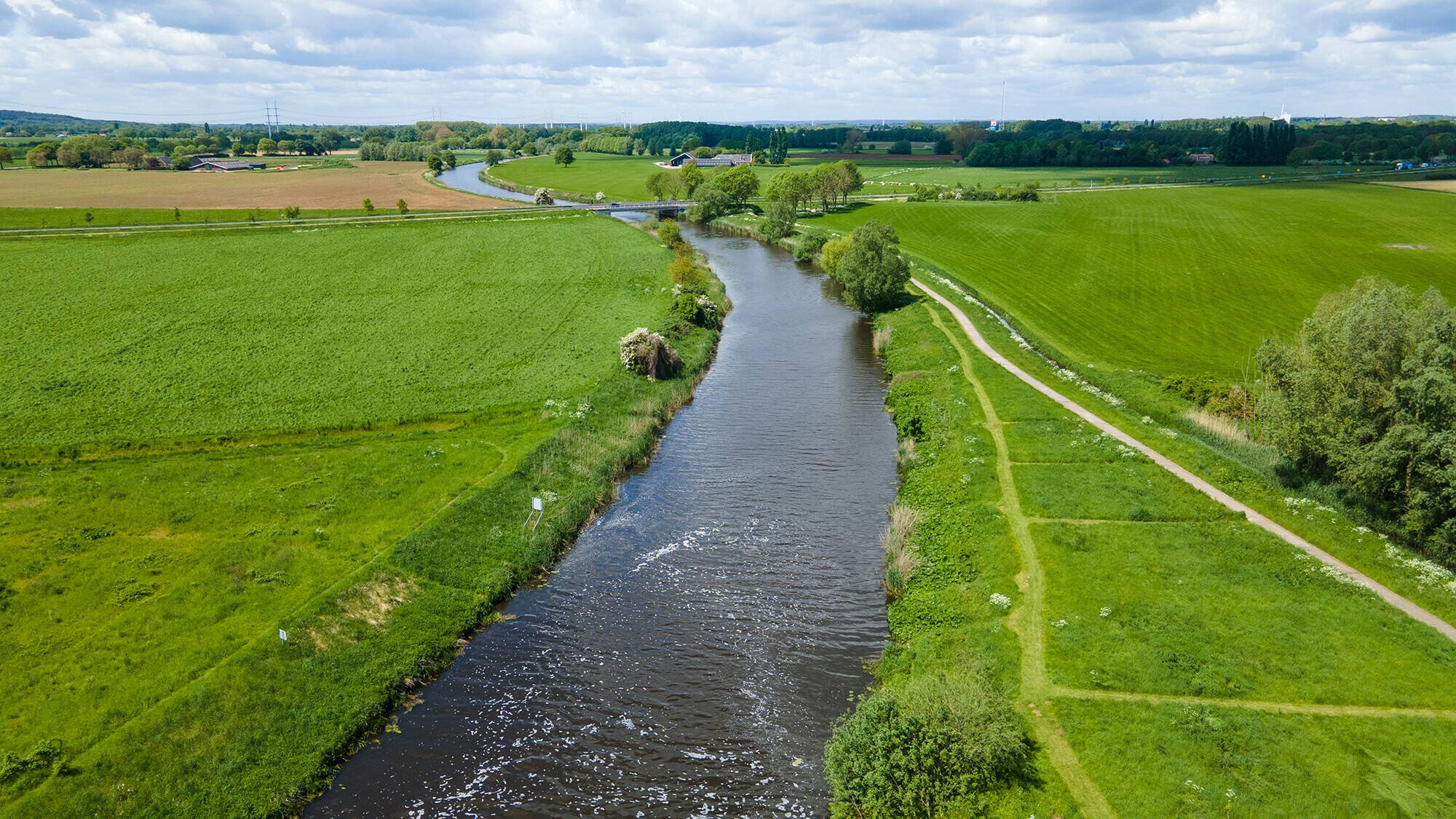 Luchtfoto van de Urkervaart, met rechts akkers en links bebouwing