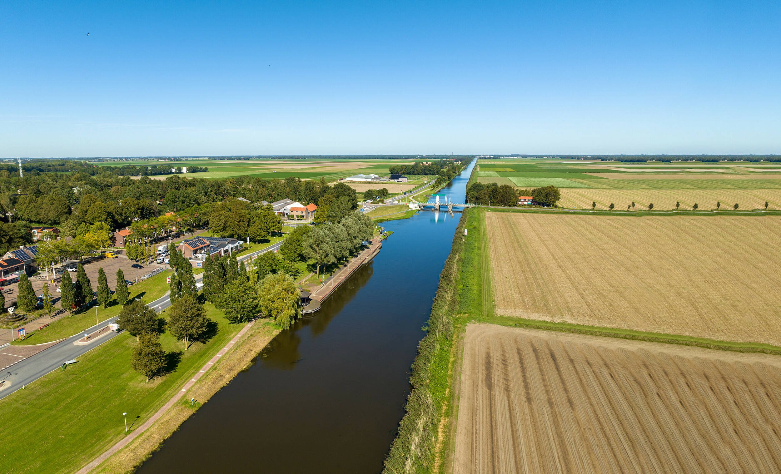 Luchtfoto van de Urkervaart, met rechts akkers en links bebouwing