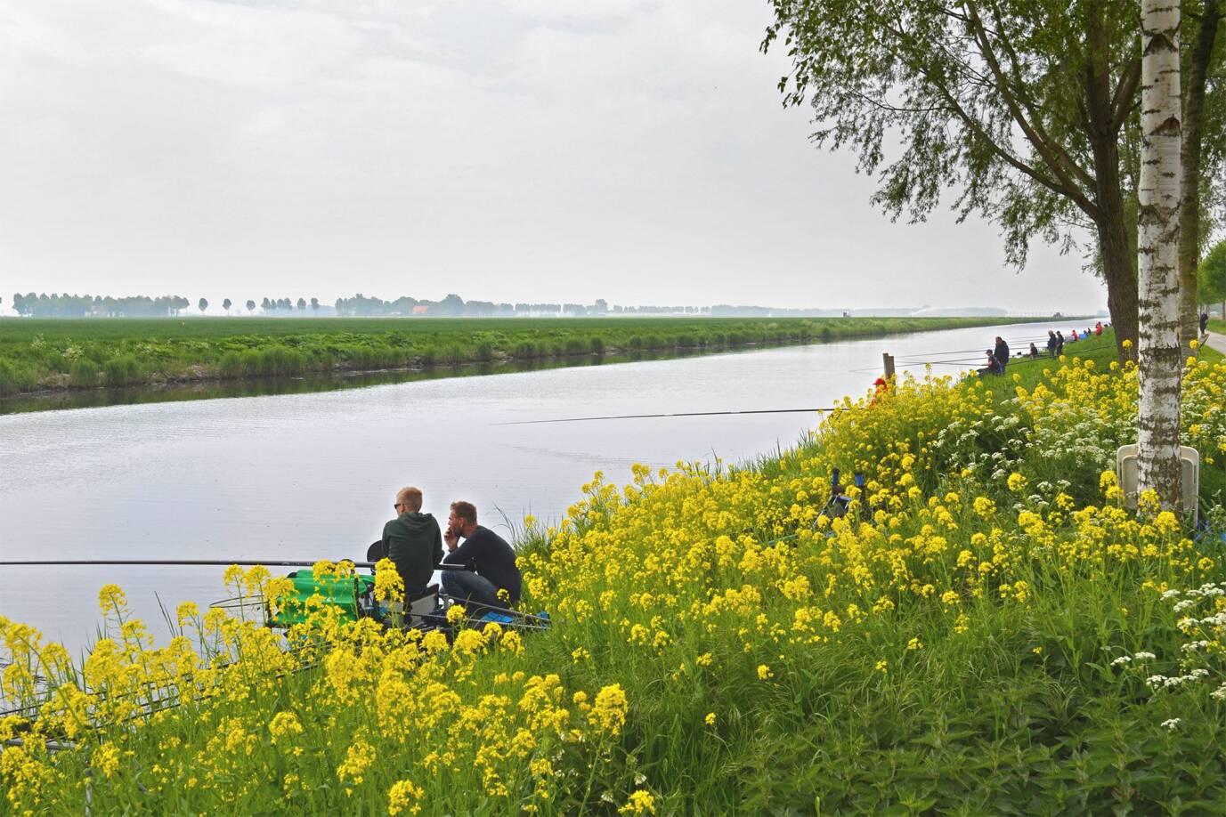 2 mensen vissen aan de vaart