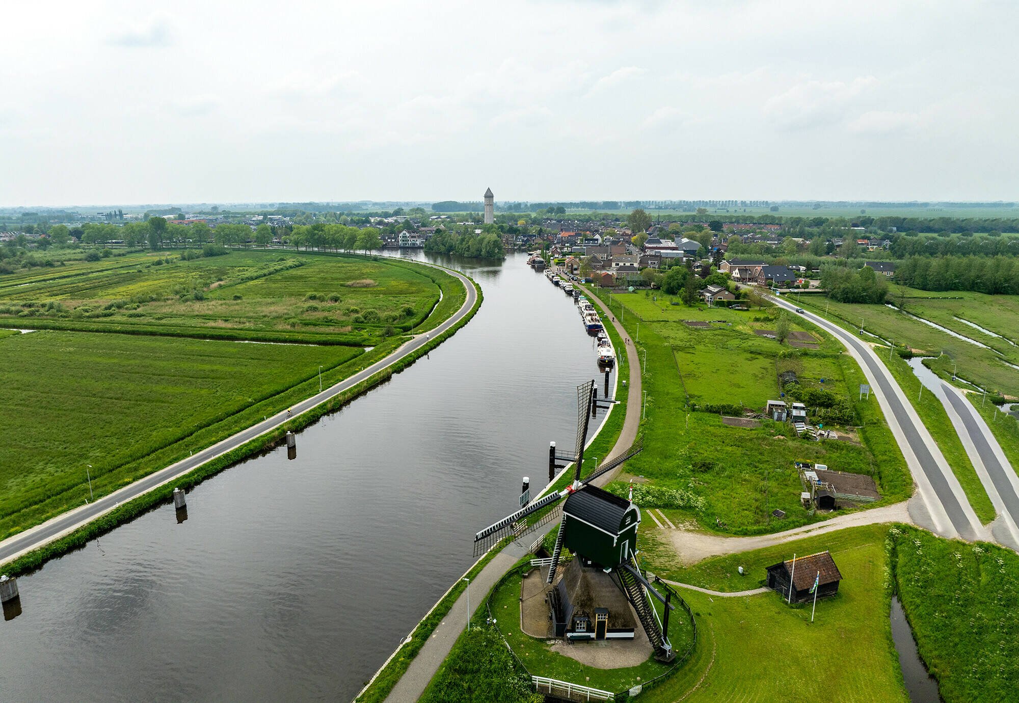 Luchtfoto van de Urkervaart, met rechts akkers en links bebouwing