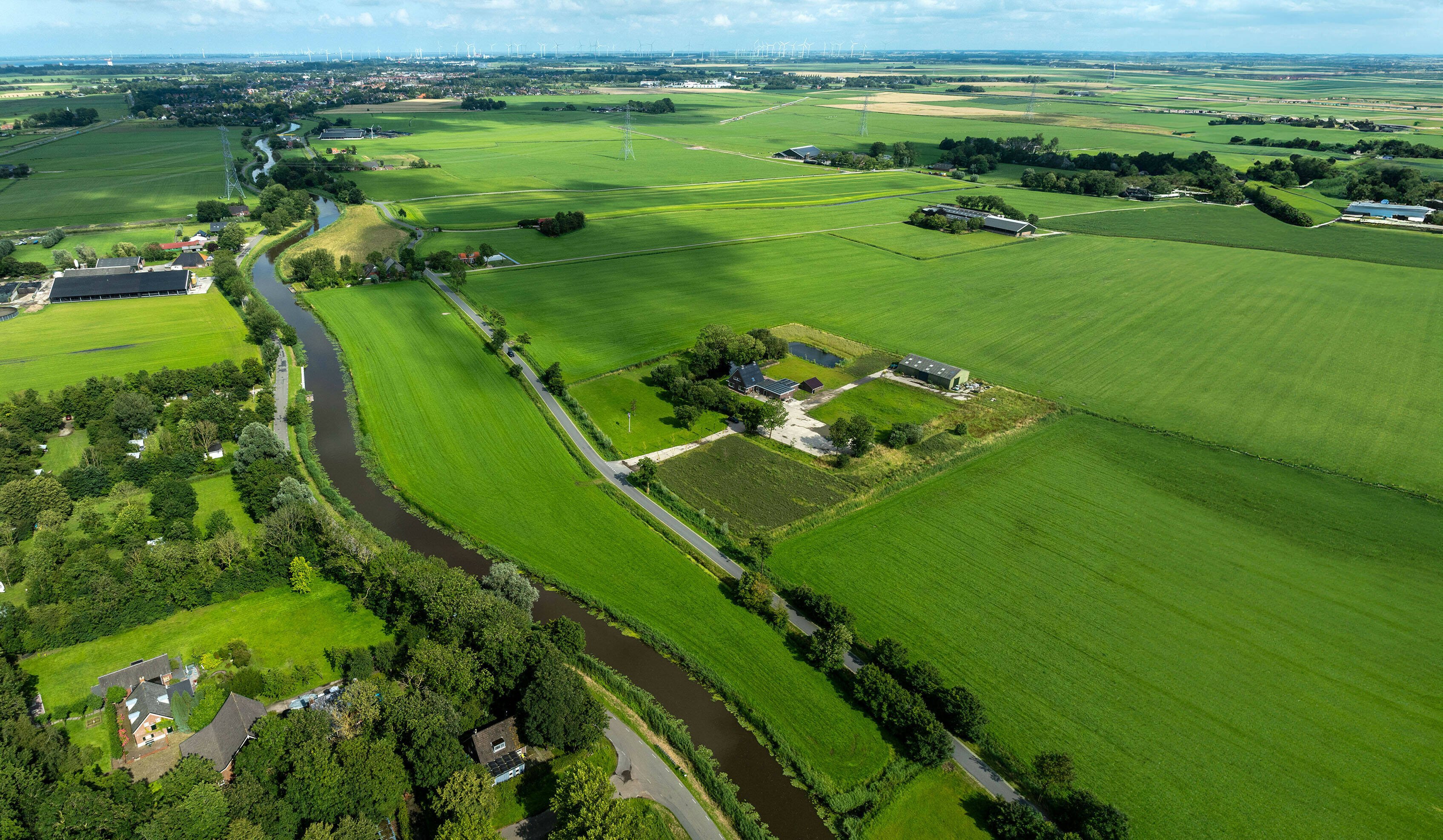 Luchtfoto van de Urkervaart, met rechts akkers en links bebouwing