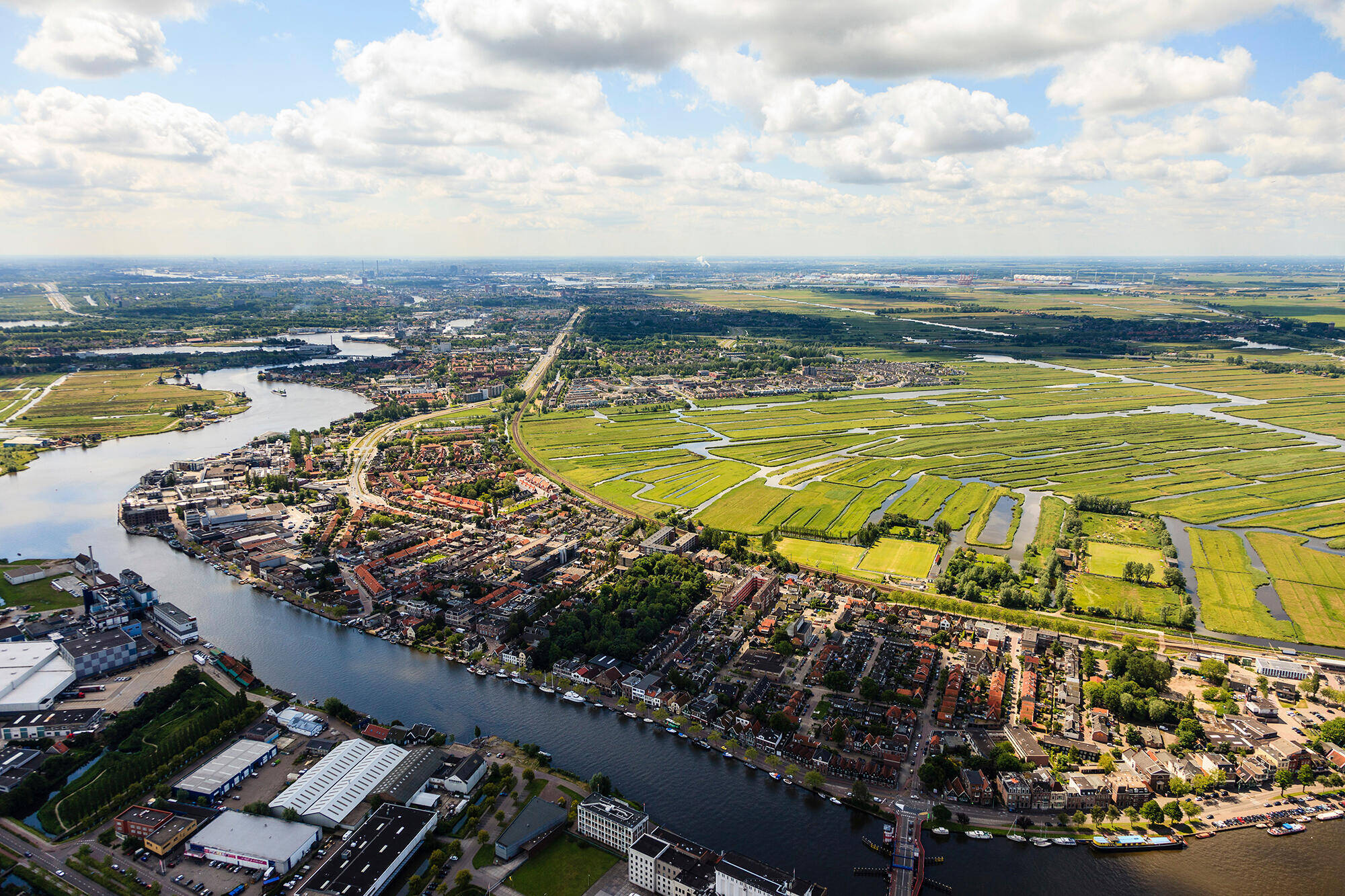 Luchtfoto van de Urkervaart, met rechts akkers en links bebouwing