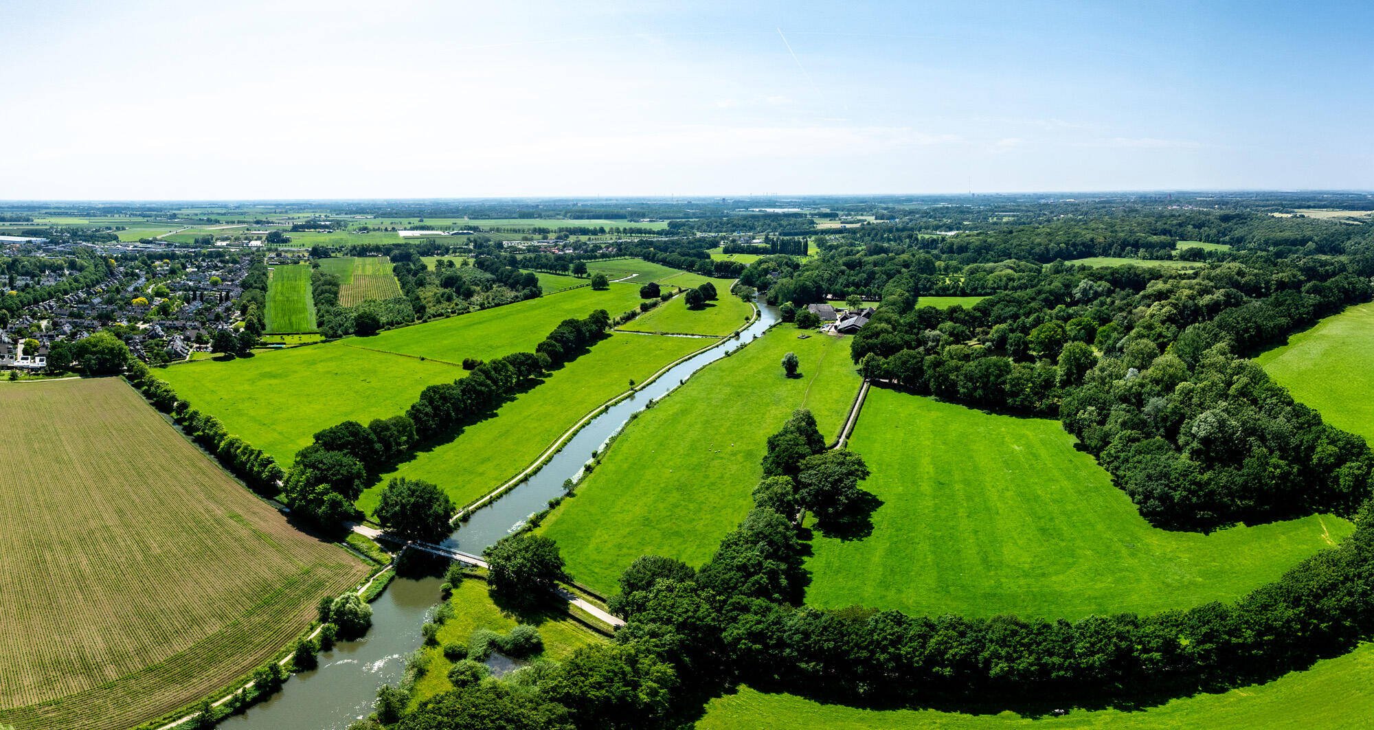 Luchtfoto van de Urkervaart, met rechts akkers en links bebouwing
