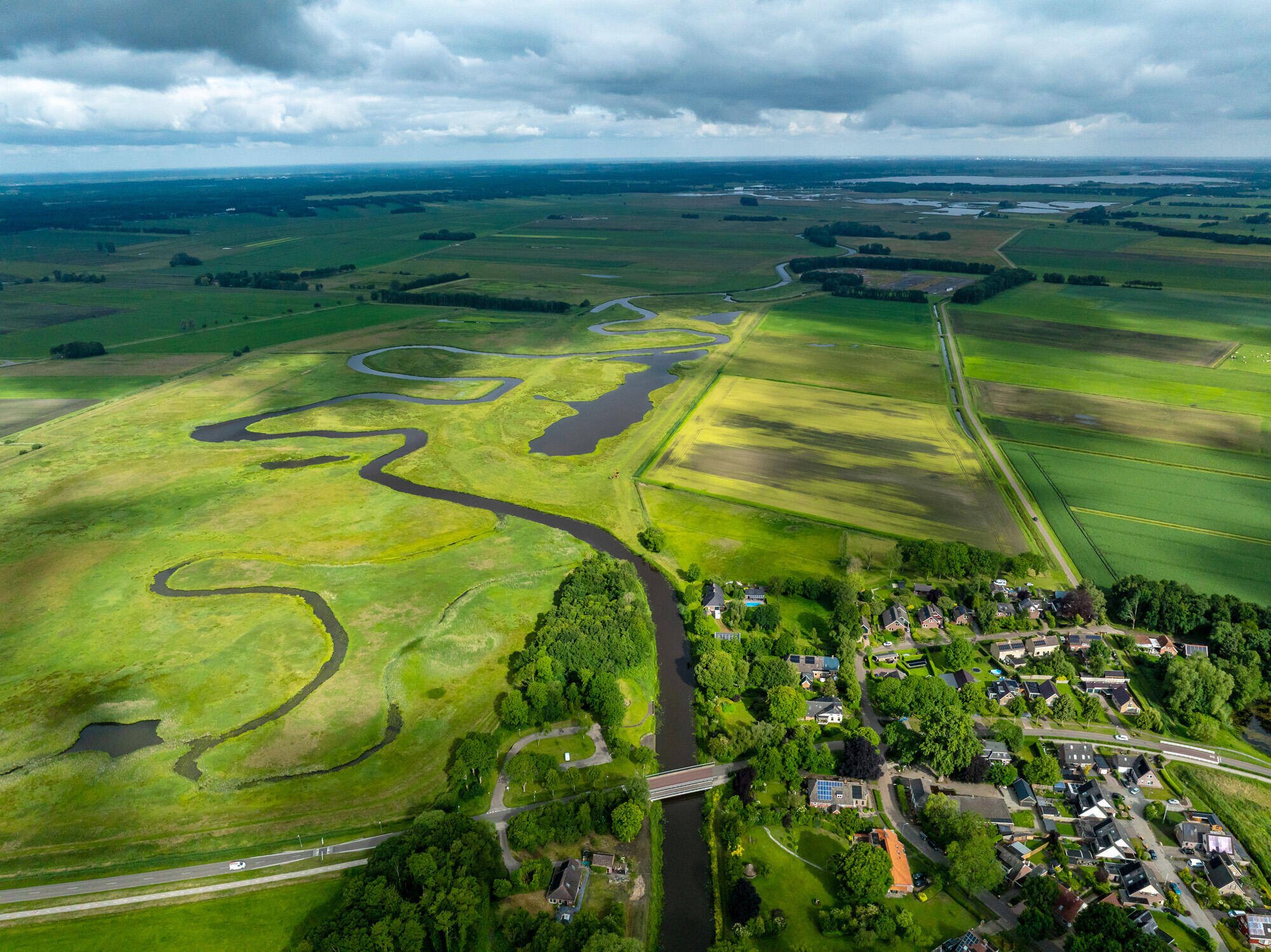 Luchtfoto van de Urkervaart, met rechts akkers en links bebouwing