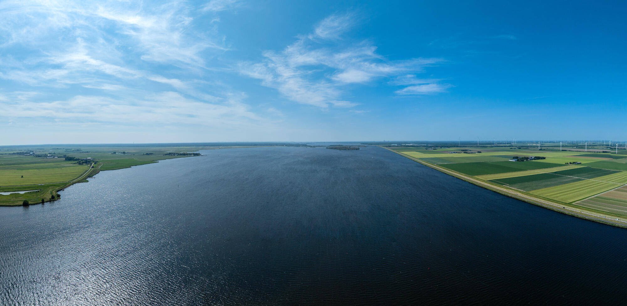 Luchtfoto van de Urkervaart, met rechts akkers en links bebouwing