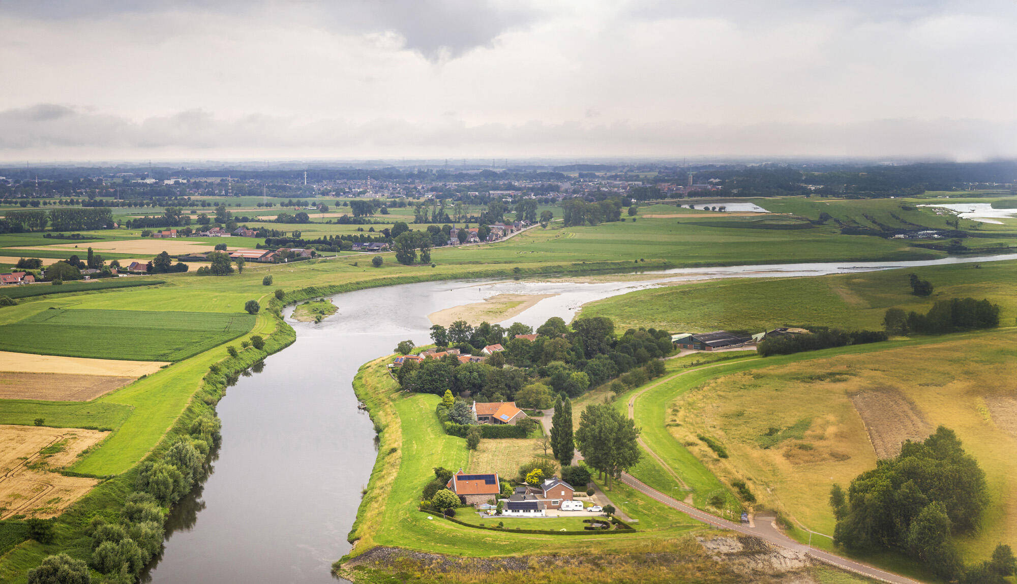 Luchtfoto van de Urkervaart, met rechts akkers en links bebouwing