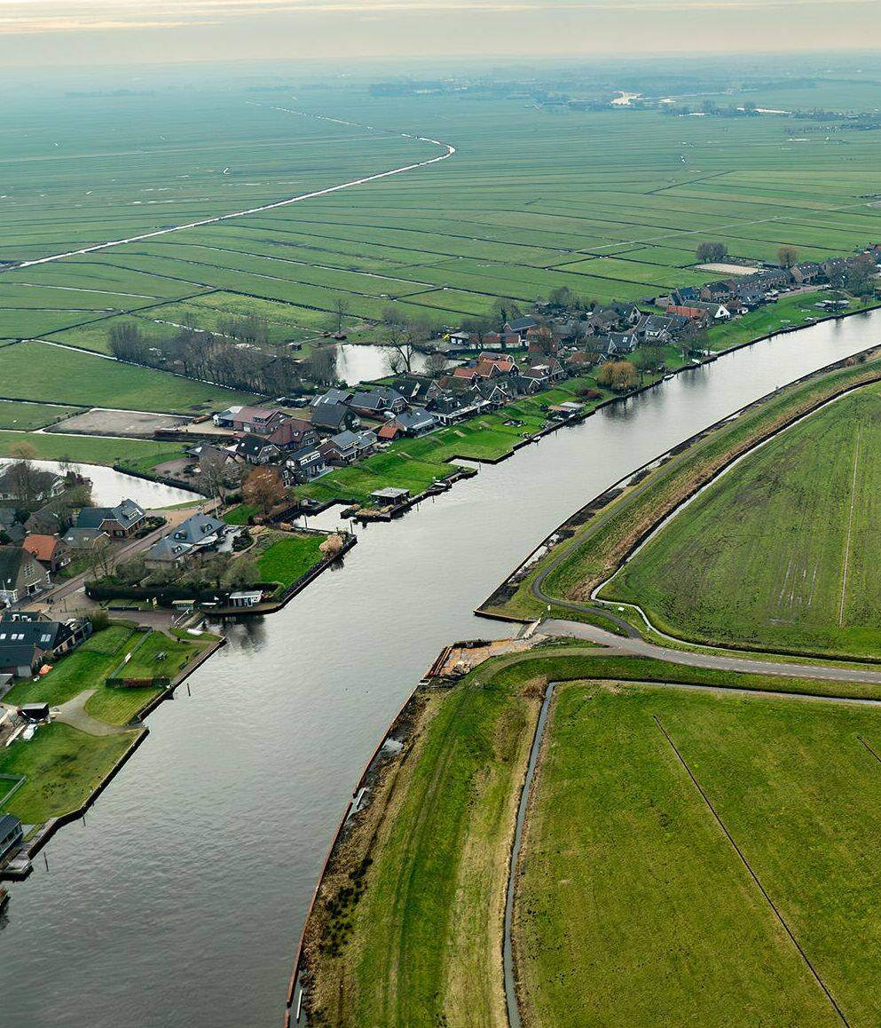 Luchtfoto van de Urkervaart, met rechts akkers en links bebouwing