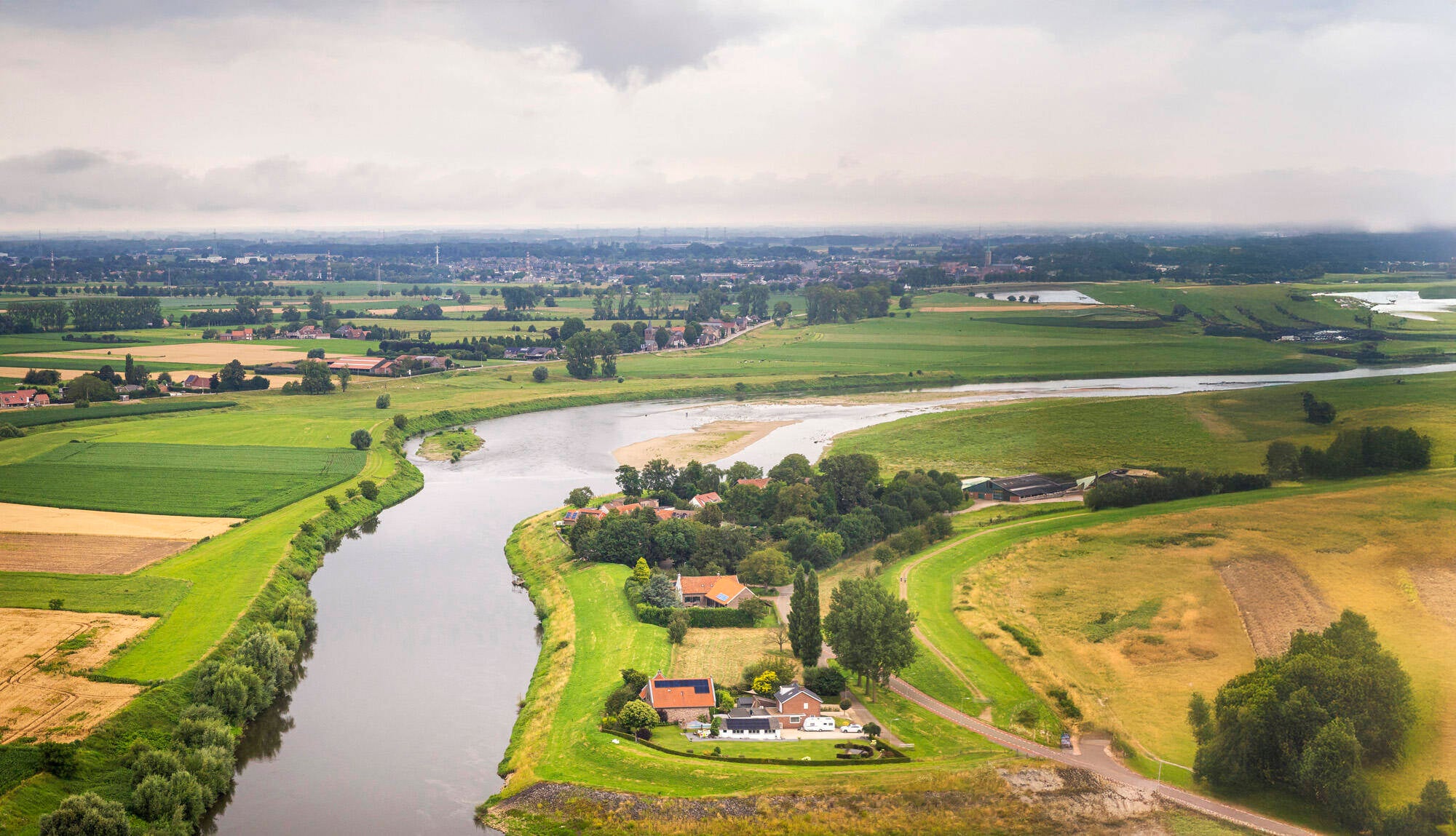 Luchtfoto van de Urkervaart, met rechts akkers en links bebouwing