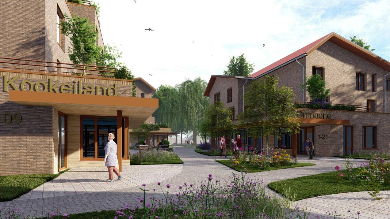 Foto van een oudere mevrouw in een rolstoel. Ze kijkt lachend naar de zorgmedewerker die haar duwt.