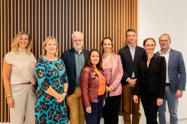 Foto van 2 medewerkers van Beweging 3.0, die lachend in de camera kijken.
