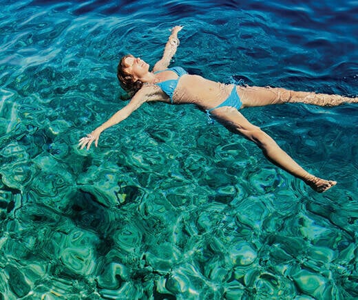 Young girl floating in the waters off Alkimos beach