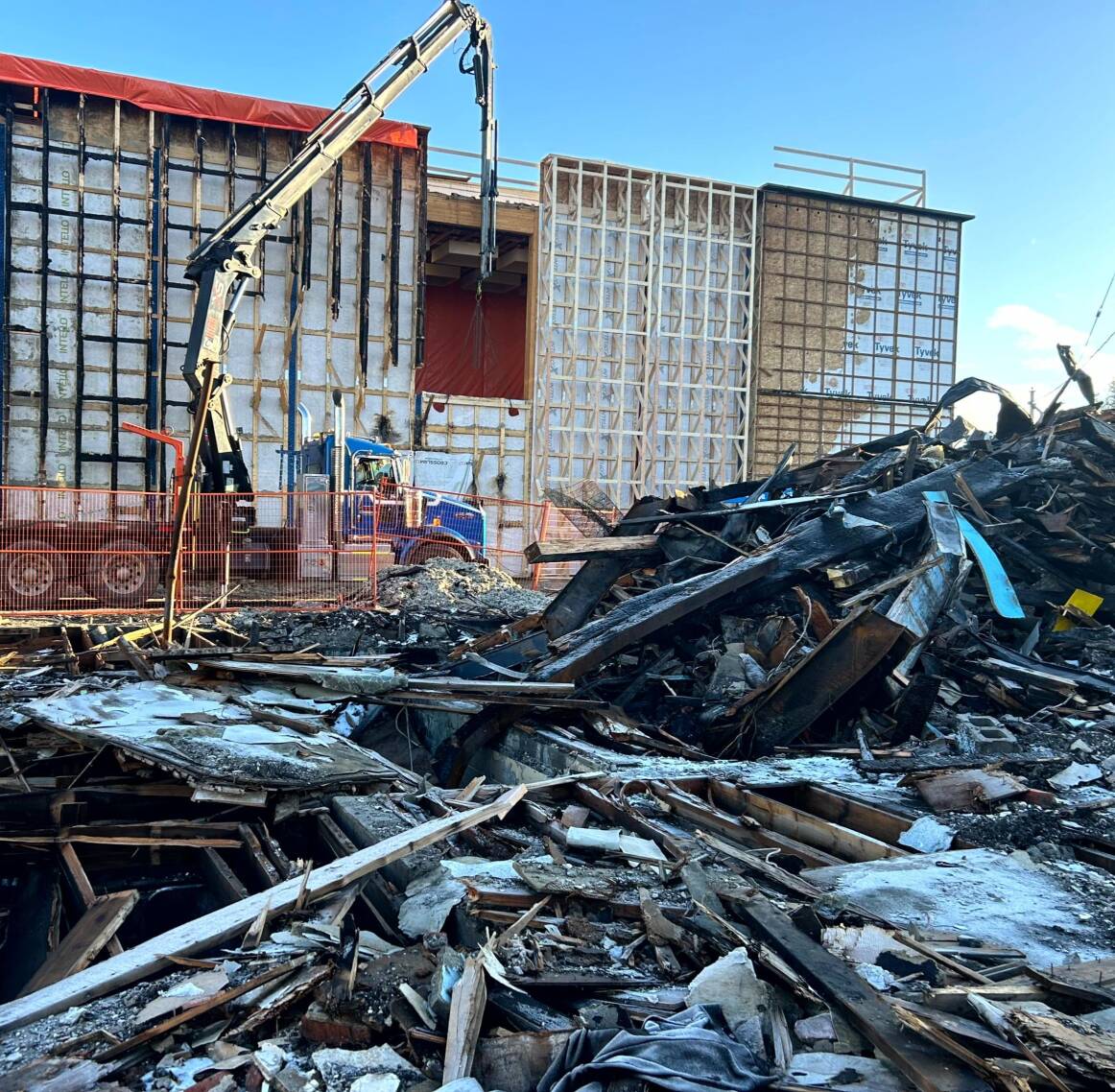 A crane is seen in front of a damaged building