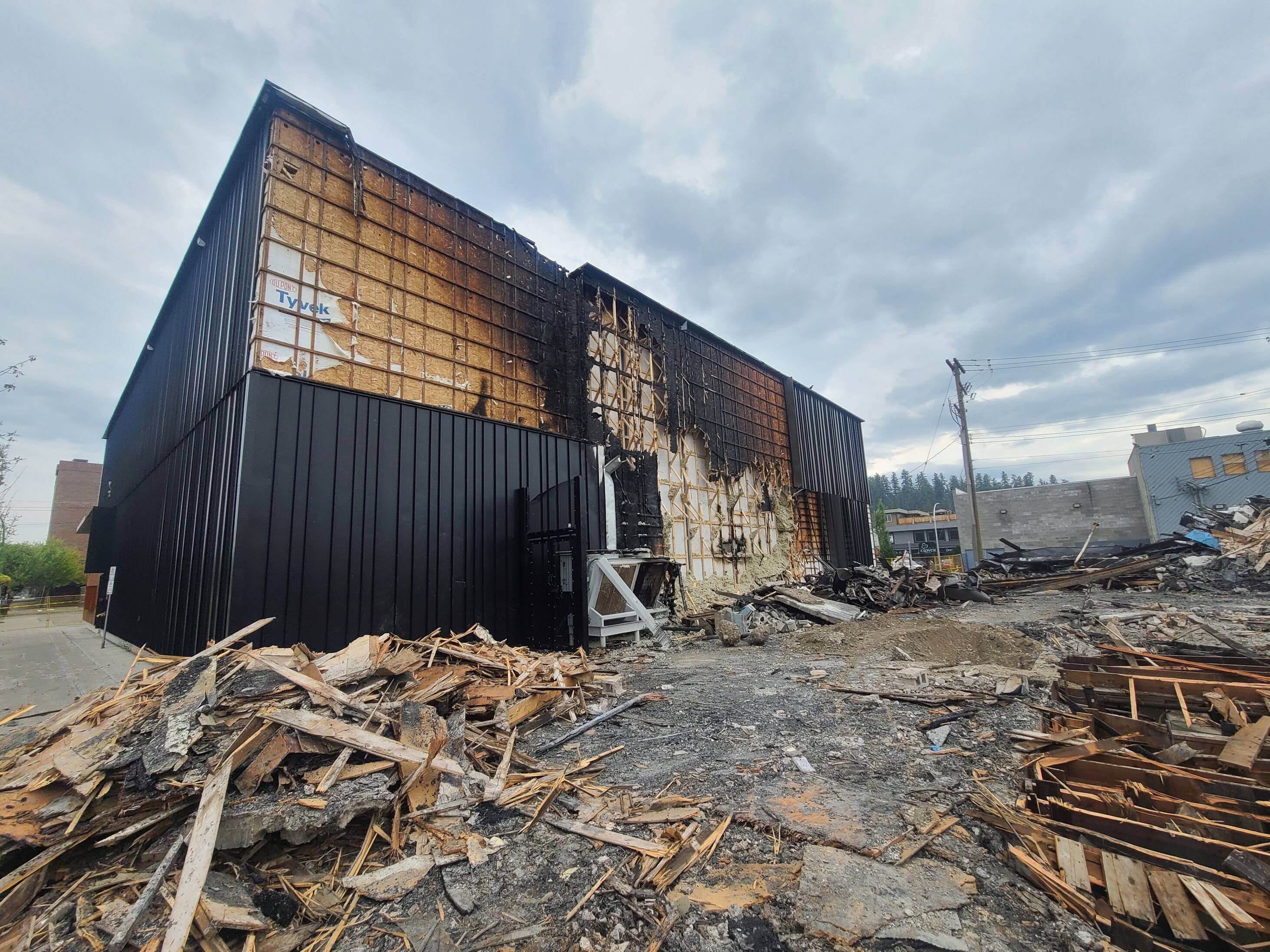 Image of a building that has fire damage, with beams and wood debris scattered in the foreground