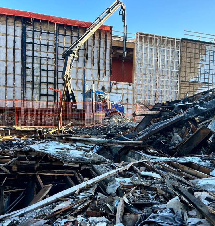 A crane is seen in front of a damaged building