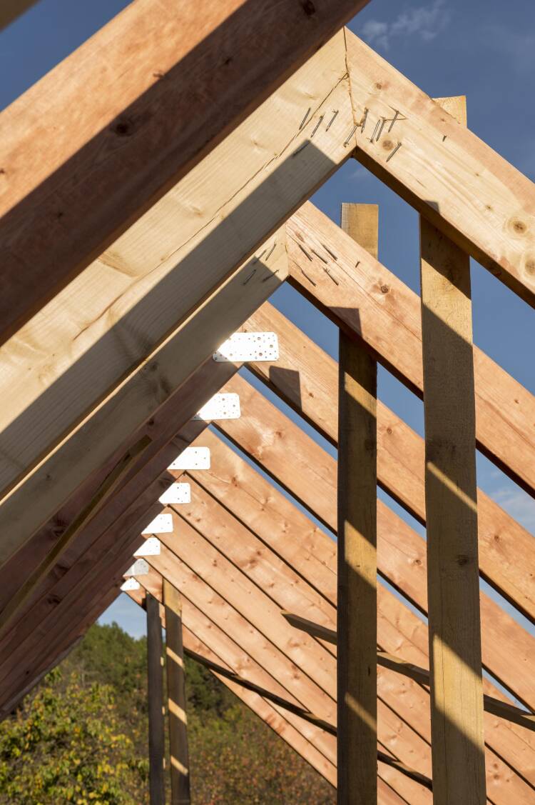 Interior of a wood framed construction site with sunlight streaming in