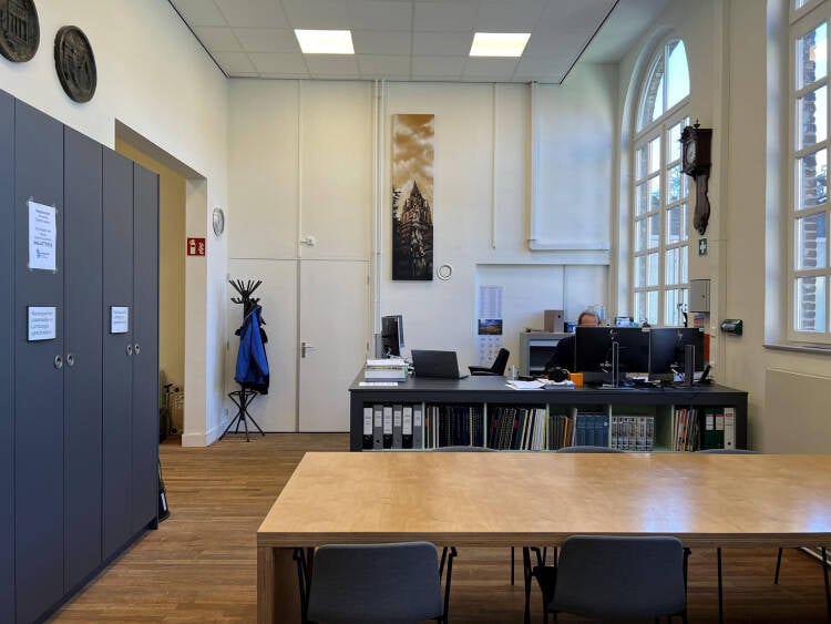 Foto: De uitleg-tafel in studiezaal met plek voor grote bouwtekeningen en kaarten, met daarachter de balie.