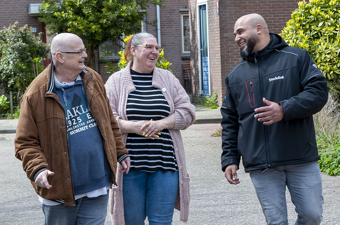 We zien twee bewoners in de wijk in gesprek met een stedelink medewerker