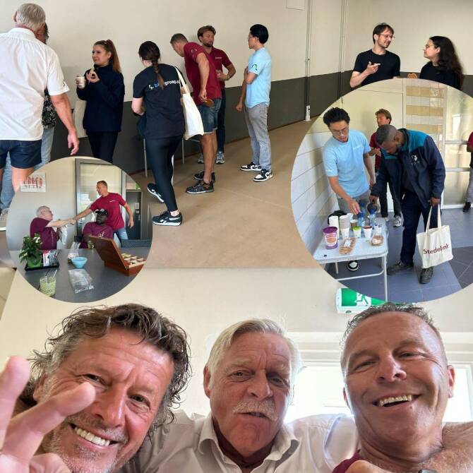 Groep schoonmaakpartners en bewoners praat samen en ontvangt cadeaus tijdens waarderingsmoment in woongebouw.