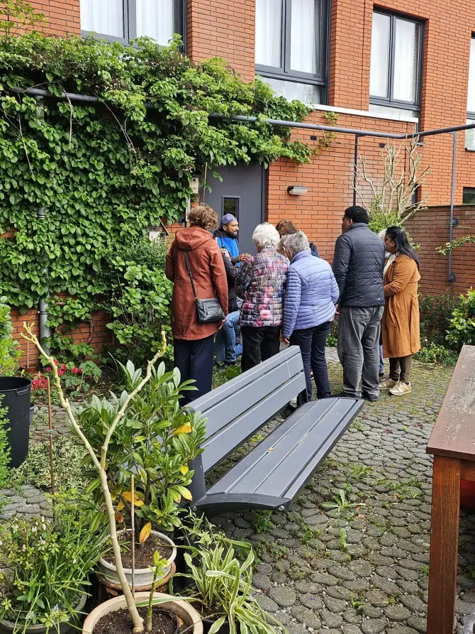 Bewoners krijgen uitleg van hovenier over onderhoud van de binnentuin.