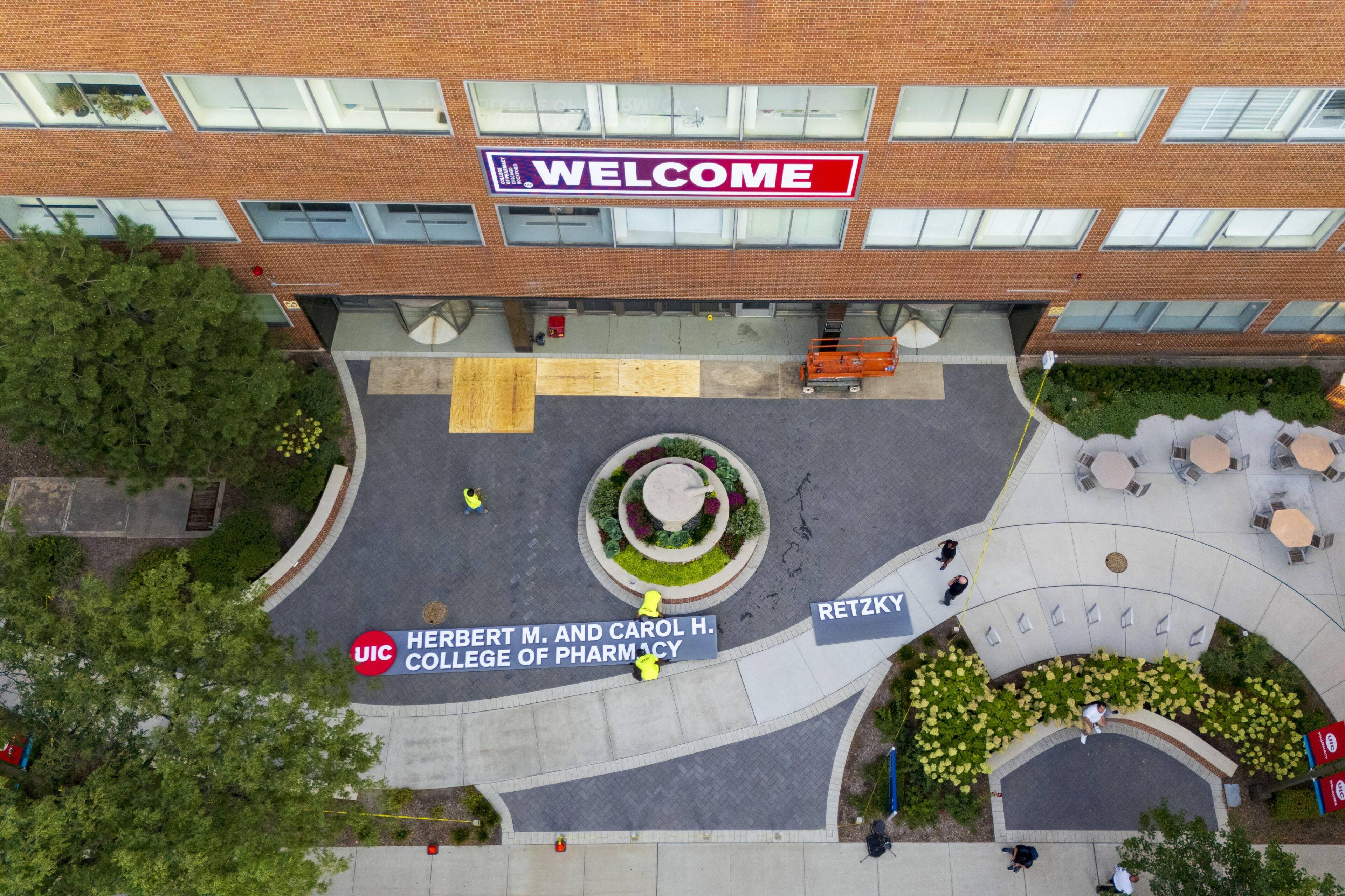 An aerial photo of the UIC College of Pharmacy installing the new sign.